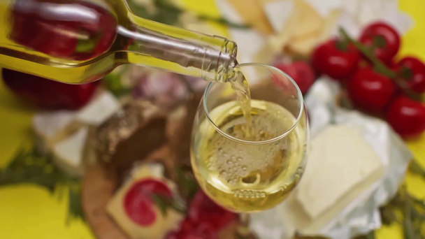 A palackból borospohárba öntött fehérbor lassú mozgása  - Felvétel, videó