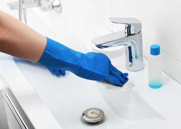 Cleaning sink and faucet with detergent.Coronavirus prevention, hygiene to stop spreading coronavirus.A maid or housewife takes care of the house. General or regular cleaning - Photo, Image