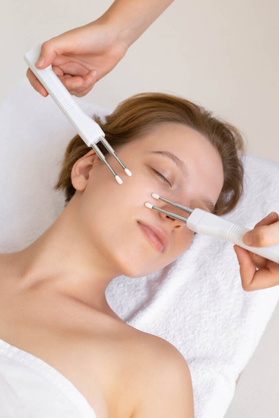 Tratamientos para la piel de la cara.Primer plano de la mujer relajada en una clínica de cosmetología. Toma de terapia microactual
. - Foto, Imagen