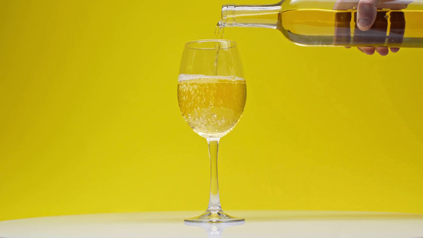 Hyperlapse van de mens gieten witte wijn in glas op geel - Video