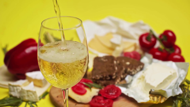 Lassan mozgó fehérbor öntés üvegben az élelmiszer közelében  - Felvétel, videó