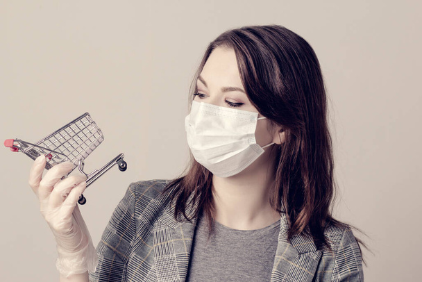Woman wearing surgical mask and gloves. Woman holds shopping cart. Healthcare and shopping concept. Covid19, Virus, Social Distancing And Quarantine.  - Fotoğraf, Görsel