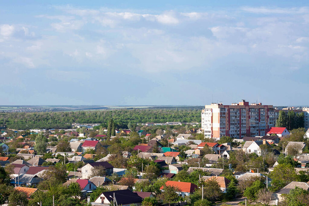 Foto del panorama de la ciudad desde el techo de un edificio residencial (noveno piso) en primavera. Hay muchos árboles y una casa de varios pisos
 - Foto, imagen
