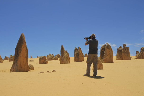 Australijski fotograf podróży fotografowania Szczyty pustyni krajobraz w pobliżu Perth w Australii Zachodniej. Pustynia zawiera tysiące formacji wapiennych zwanych szczytami. - Zdjęcie, obraz