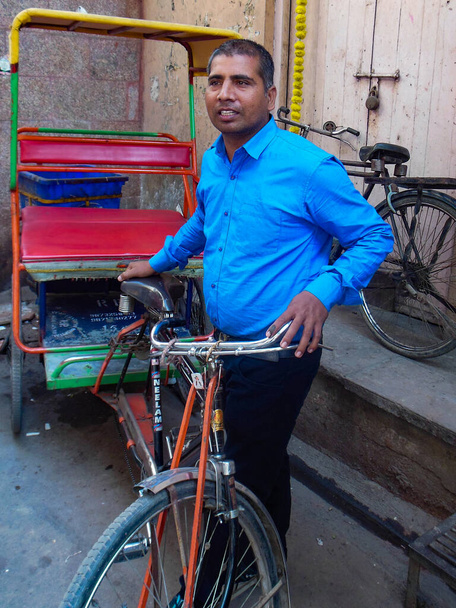 Delhi, India - December 9, 2019: Cycle rickshaw riding the vehicle under the heat on the street of Old Delhi, India, Street Photography of Rickshaw in Chandni Chowk market - Fotó, kép