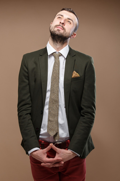 dromen stijlvolle jongeman in een groen pak en oranje jeans - Foto, afbeelding