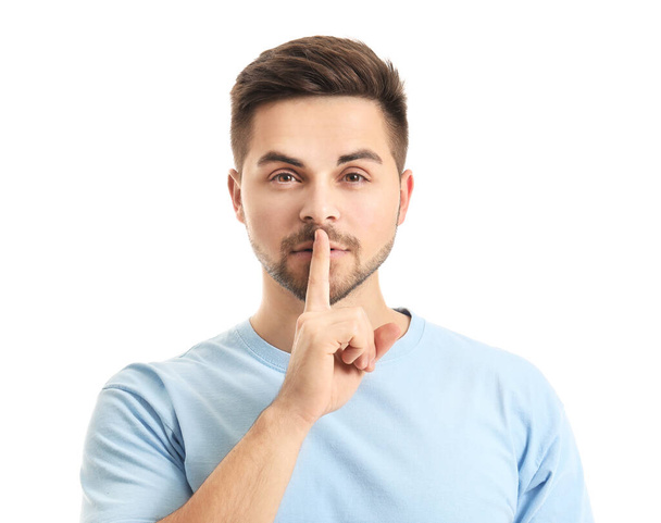 Young man showing silence gesture on white background - Fotoğraf, Görsel
