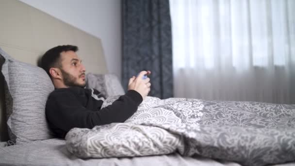 Zieke man hoesten tijdens het spelen van games met controller thuis - Video