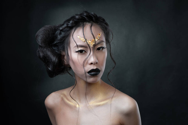 Porträt einer jungen Frau mit kreativen Haaren vor dunklem Hintergrund - Foto, Bild