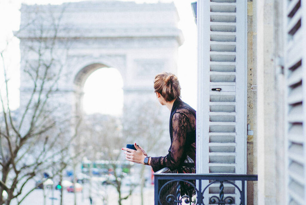 Attractive yang woman in pajama is drinking coffee on balcony  - Foto, immagini