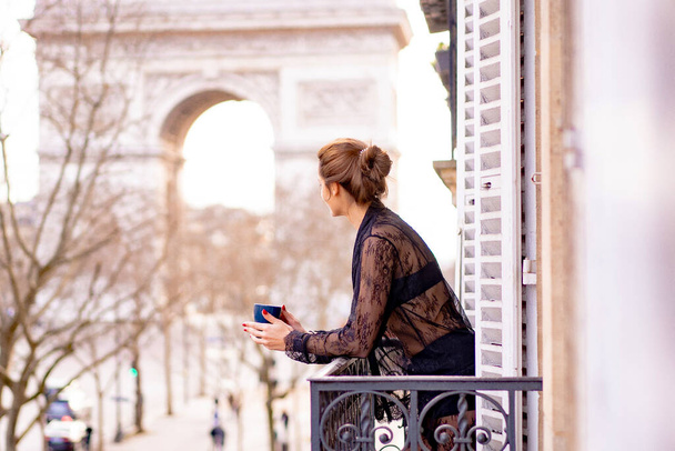 Attractive yang woman in pajama is drinking coffee on balcony  - Фото, зображення