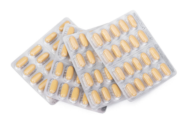 Желтые таблетки в пузыре пакет изолирован на белом фоне - Фото, изображение