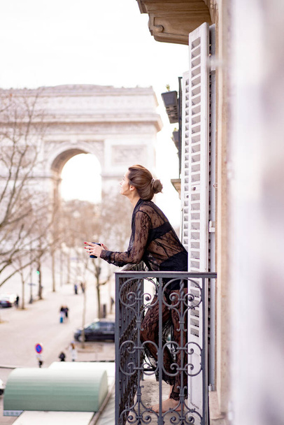 Attractive yang woman in pajama is drinking coffee on balcony  - Valokuva, kuva