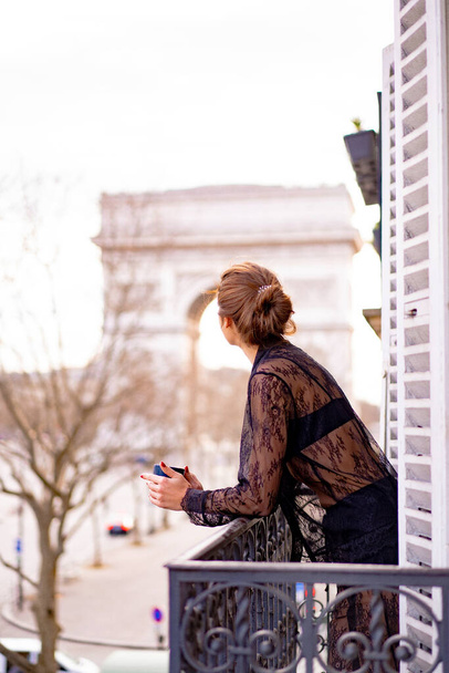 Attractive yang woman in pajama is drinking coffee on balcony  - Valokuva, kuva
