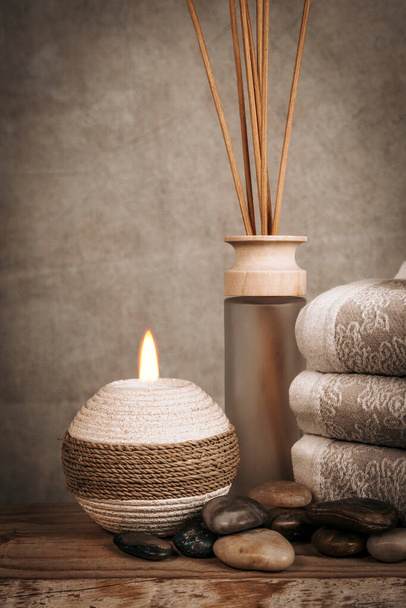 Spa essentials, aroma sticks, stones, towels, sea shell on a wooden rustic background - Foto, afbeelding