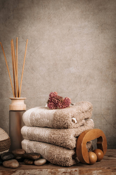 Esenciales de spa, palitos de aroma, piedras, toallas, concha de mar sobre un fondo rústico de madera
 - Foto, imagen