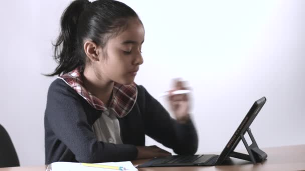 брюнетка Латинська студентка зі шкільною формою в різних позах, нудно, усміхнено, вдумливо, вивчає, концентрується, використовуючи ipad і письмо
 - Кадри, відео
