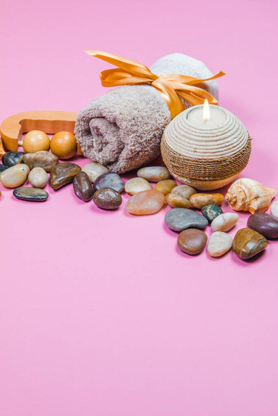 Spa niezbędne, aromatyczne paluszki kamienie, ręczniki i roślina na różowym tle - Zdjęcie, obraz