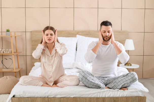 Jeune couple ne peut pas dormir à cause de voisins turbulents
 - Photo, image