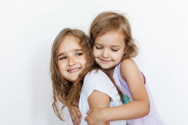 Two girls, sisters, hugging each other, relationships, communication, family, support and joy, emotions, baby, quarrels - Photo, Image