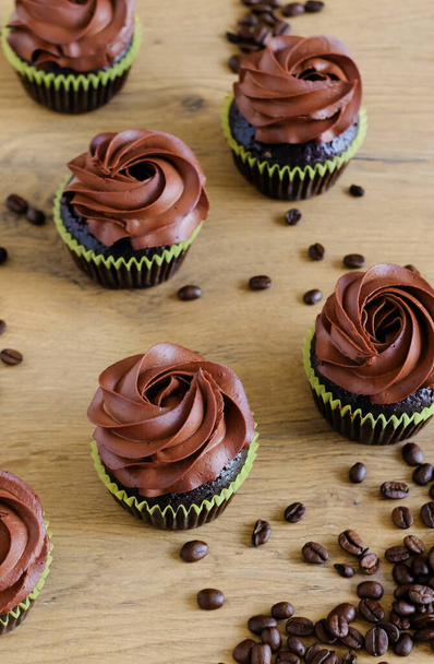Tumma suklaa kahvi cupcakes puinen ruskea pöytä tausta. Makea ruoka käsite.  - Valokuva, kuva