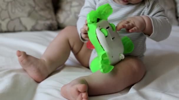 Little boy at the age of 8 months plays with toys, development of motility skills, caucasian - Πλάνα, βίντεο
