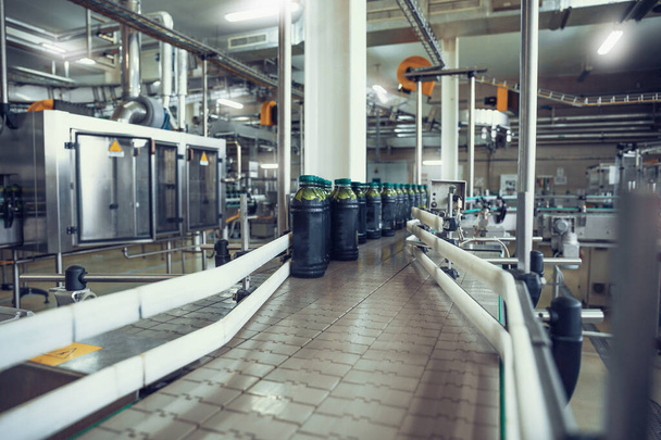 İçecek fabrikası teçhizatı üzerinde meyve suyu şişeleri olan taşıyıcı bant ya da hat - Fotoğraf, Görsel