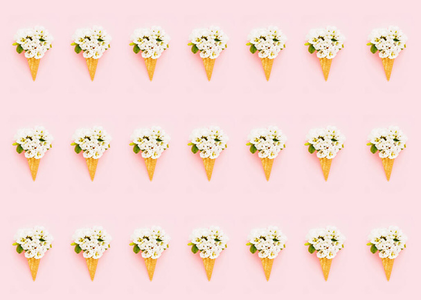 Pattern. Waffle ice cream cone with blooming pear flower on pink background. Spring concept. Copy space for text, top view. - Fotografie, Obrázek