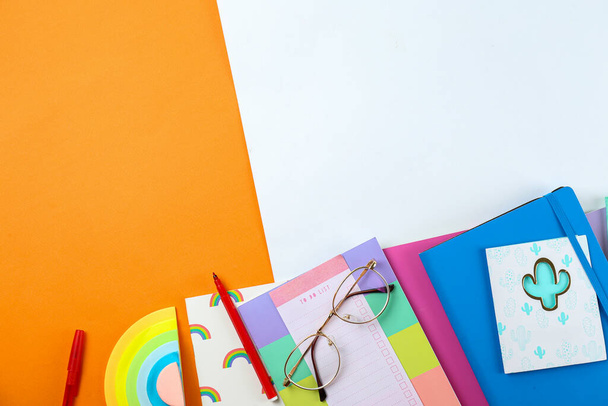 Back to school concept. Set of different school supplies, notebook, pen, accessories on orange paper textured background. Various scolorful stationery items. Close up, copy space, top view, flat lay. - 写真・画像