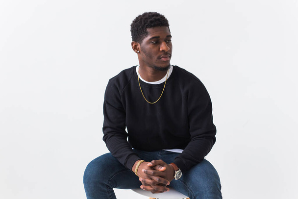Youth street fashion concept - Portrait of confident sexy black man in stylish sweatshirt on white background. - Фото, изображение