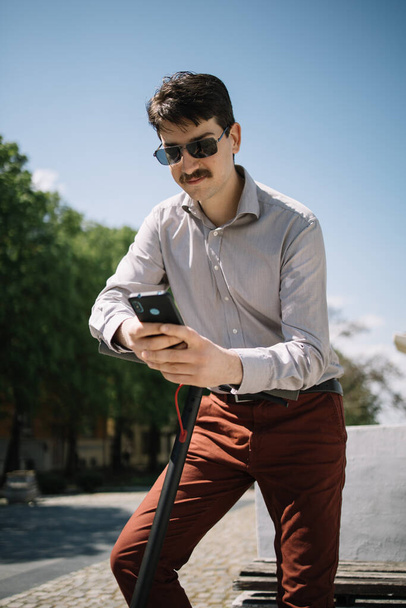 Young man with facial hair looking his phone - Foto, afbeelding