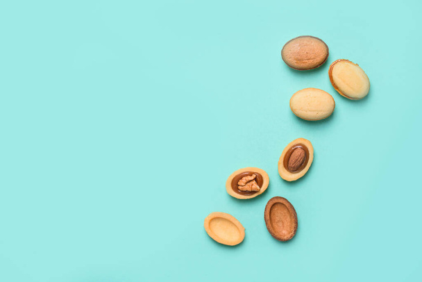 Homemade nuts with condensed milk, chocolate inside, walnuts and almonds. Nuts on a light blue background. A place for text. Flat lay - Photo, Image
