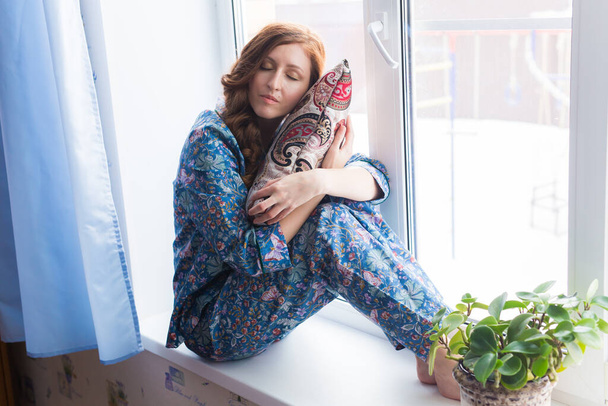 Genç kızıl saçlı kadın evde dinleniyor. Karantina, izolasyon, koronavirüs salgını. Evde kal.. - Fotoğraf, Görsel