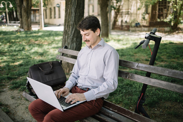 Guy in elegant outfit working on computer in park - Foto, afbeelding