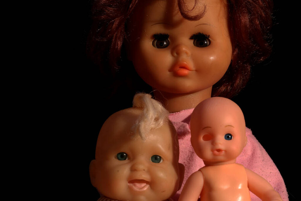 Старі ляльки на темному тлі
 - Фото, зображення