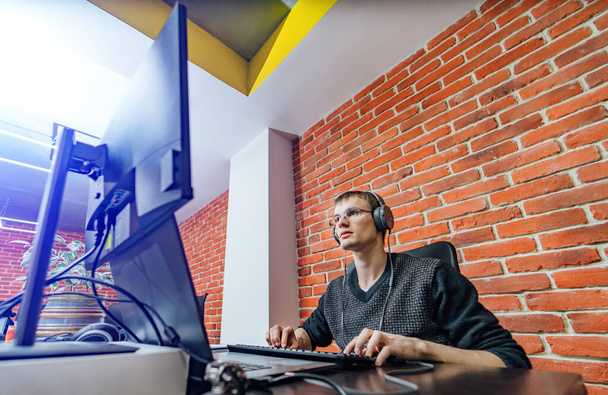 Website design programming and coding technologies. Man at work near computer. Male in headphones. Creative office - Fotoğraf, Görsel