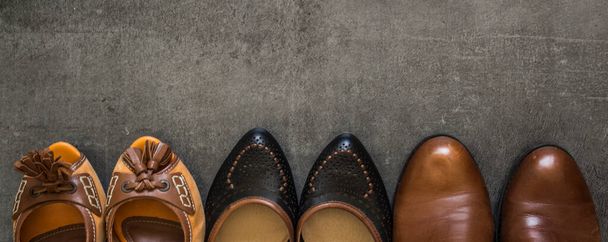 Zapatos de cuero de diferentes colores en una fila. Foto de vista superior. Fondo gris con espacio de copia
.  - Foto, imagen