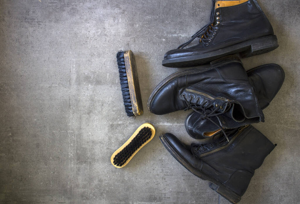 Μαύρα δερμάτινα ρετρό παπούτσια και ξύλινη βούρτσα παπουτσιών σε γκρι φόντο με αντιγραφικό χώρο.  - Φωτογραφία, εικόνα