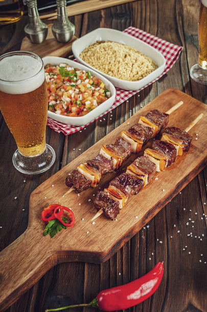 Grilled meat stick with beer and ingredients - Brazilian espetinho de carne - Foto, immagini