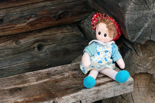 Child doll on wooden bench  - Photo, Image