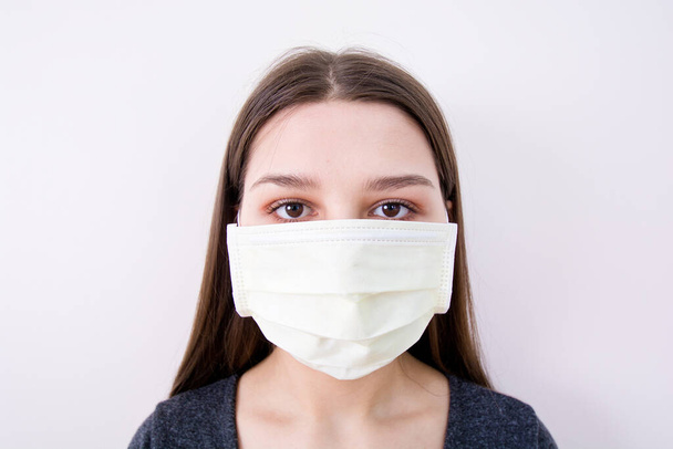 Young woman wears a face mask. Isolated image. Covid-19 concept. - Foto, imagen