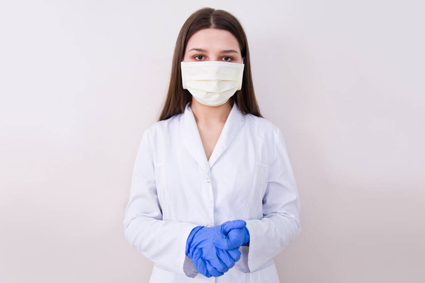Female doctor wearing protection face mask and gloves. Covid-19 concept. - Photo, Image