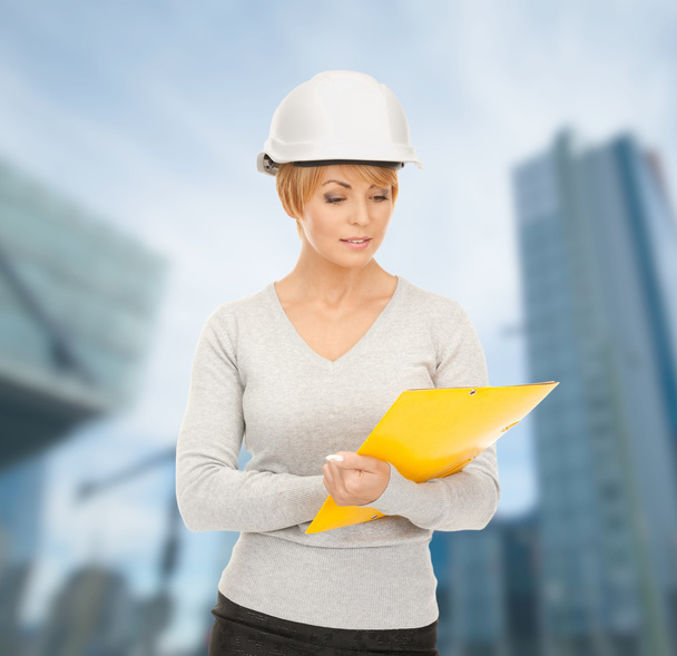 Female contractor in helmet with blueprint - Photo, image
