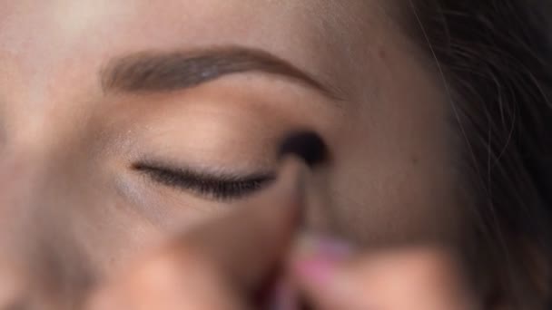 Macro shot of Professional Makeup for beautiful and gorgeous woman sitting at the Studio. Make up Artist applies blush with brush on eyelid - Footage, Video