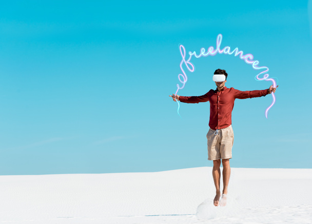 чоловік на піщаному пляжі в гарнітурі vr стрибає на прозоре блакитне небо, позаштатна ілюстрація
  - Фото, зображення