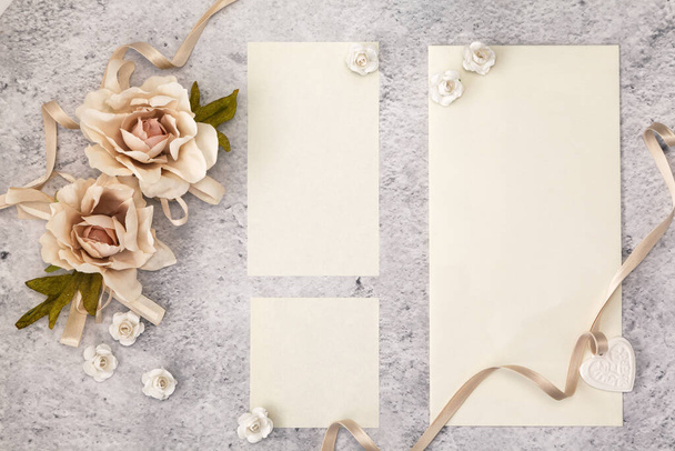 Wedding invitation cards papers laying on table decorated with roses - Photo, image
