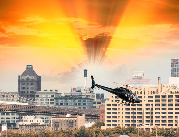 Schwarzer Hubschrauber schwebt über New Yorker Gebäuden - Foto, Bild
