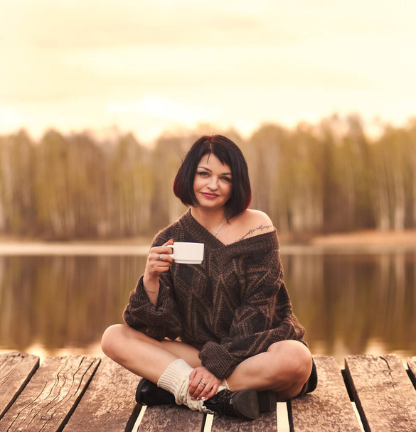 young cute girl drinks coffee outdoors emotions - Foto, Imagen
