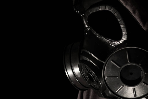 Człowiek nosi maskę gazową w ciemnym pokoju. - Zdjęcie, obraz
