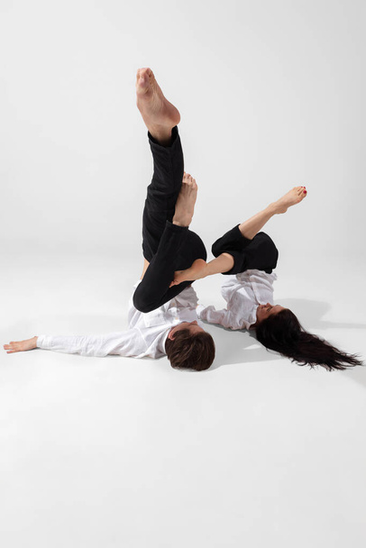 Jovens e graciosos bailarinos em estilo preto mínimo isolado no fundo do estúdio branco - Foto, Imagem
